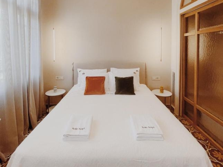 Cama de casal, almofadas, mesas laterais, luminárias pendentes, design moderno