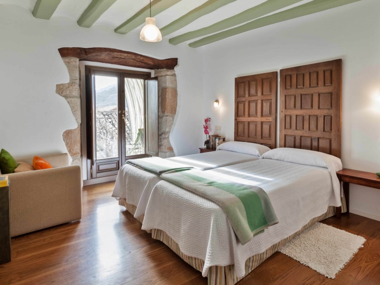  Casa La Rinconada in Azuelo Navarra offers a spacious holiday home with three bedrooms and two bathrooms. The living room features a sofa and parquet floors, providing a comfortable space for relaxation.