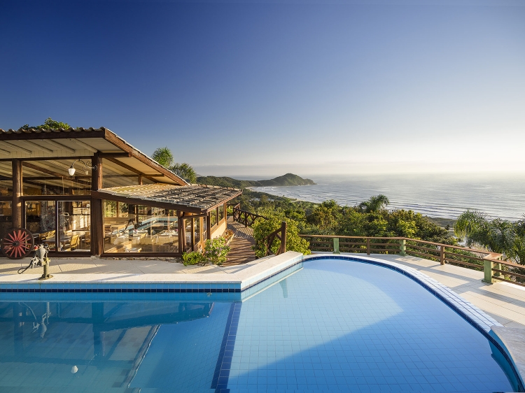 Piscina de borda infinita com aquecimento solar e vista panorâmica da Praia do Rosa