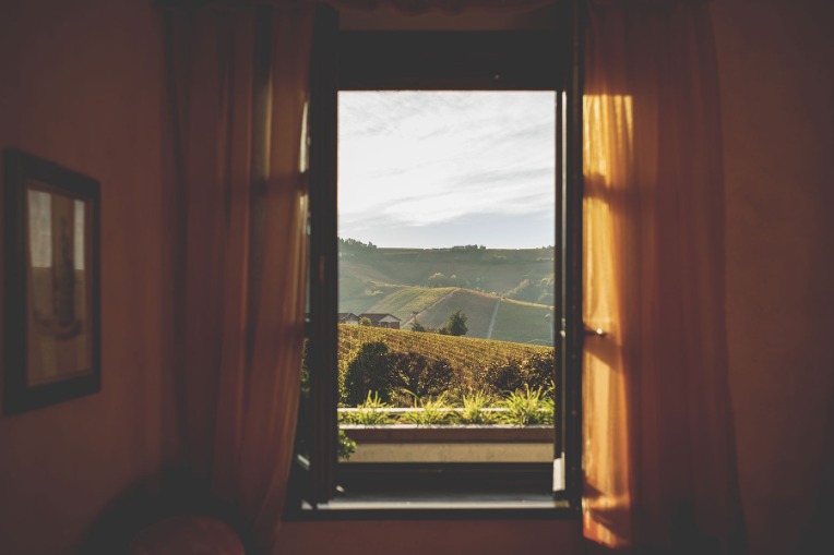 View from a window of Cascina Barac over green landscape